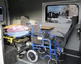 Носилки и инвалидная коляска в салоне автомобиля